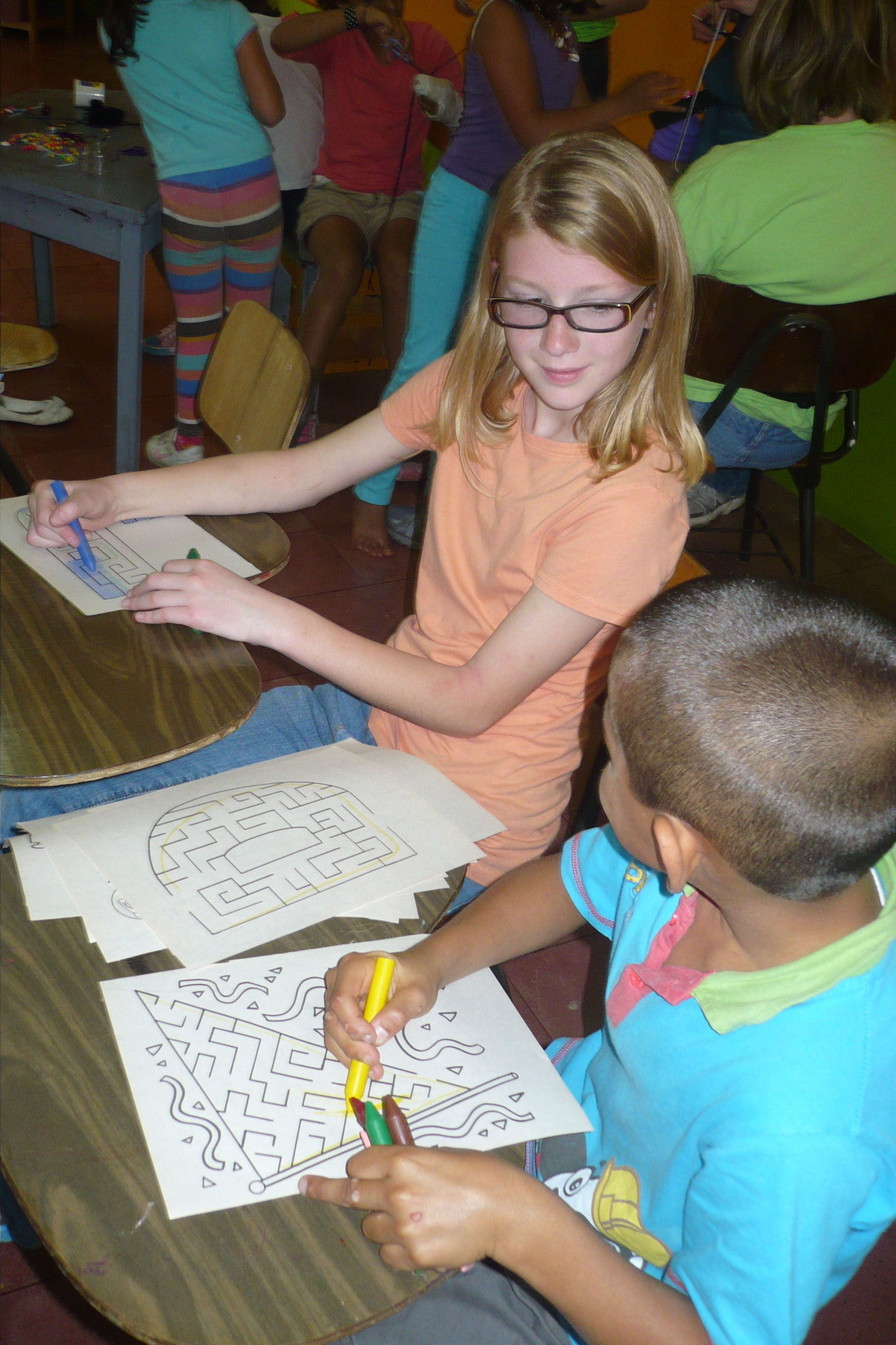 Jane Spreckelson coloring with a young boy in Costa Rica.