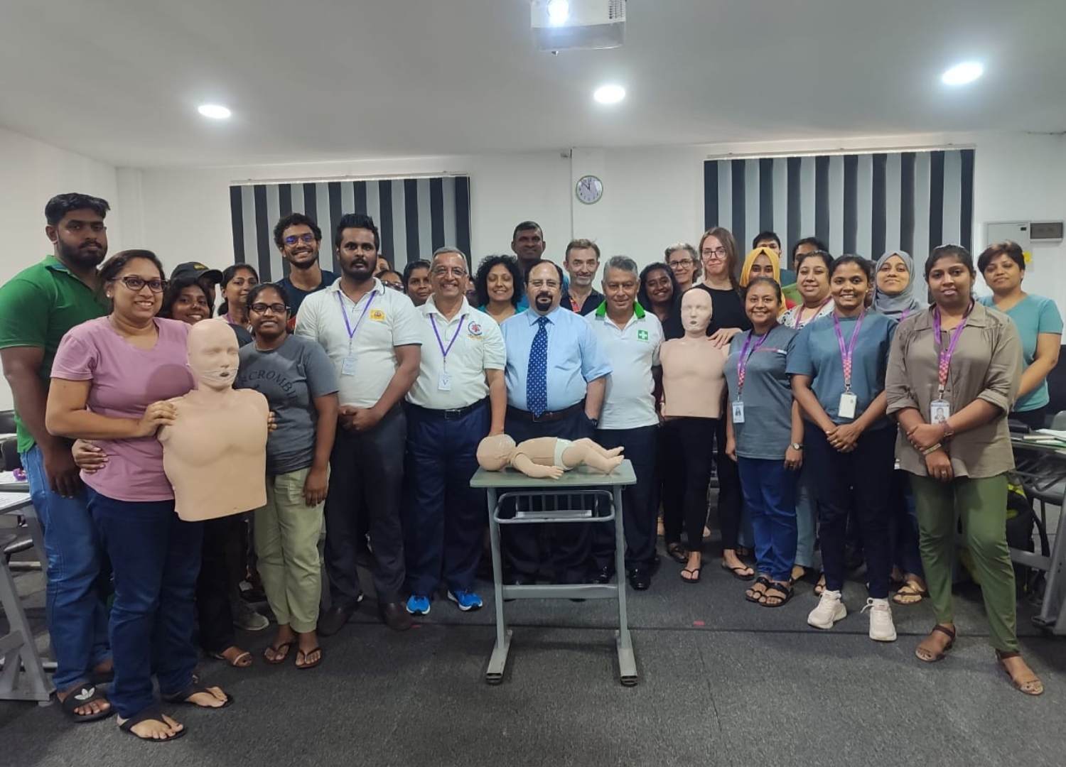 Group photo of participants after completing a life-saving skill training session with CPR mannequins.