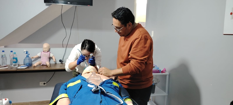 Sali trainer teaching a female student basic airway technique using a mannequin
